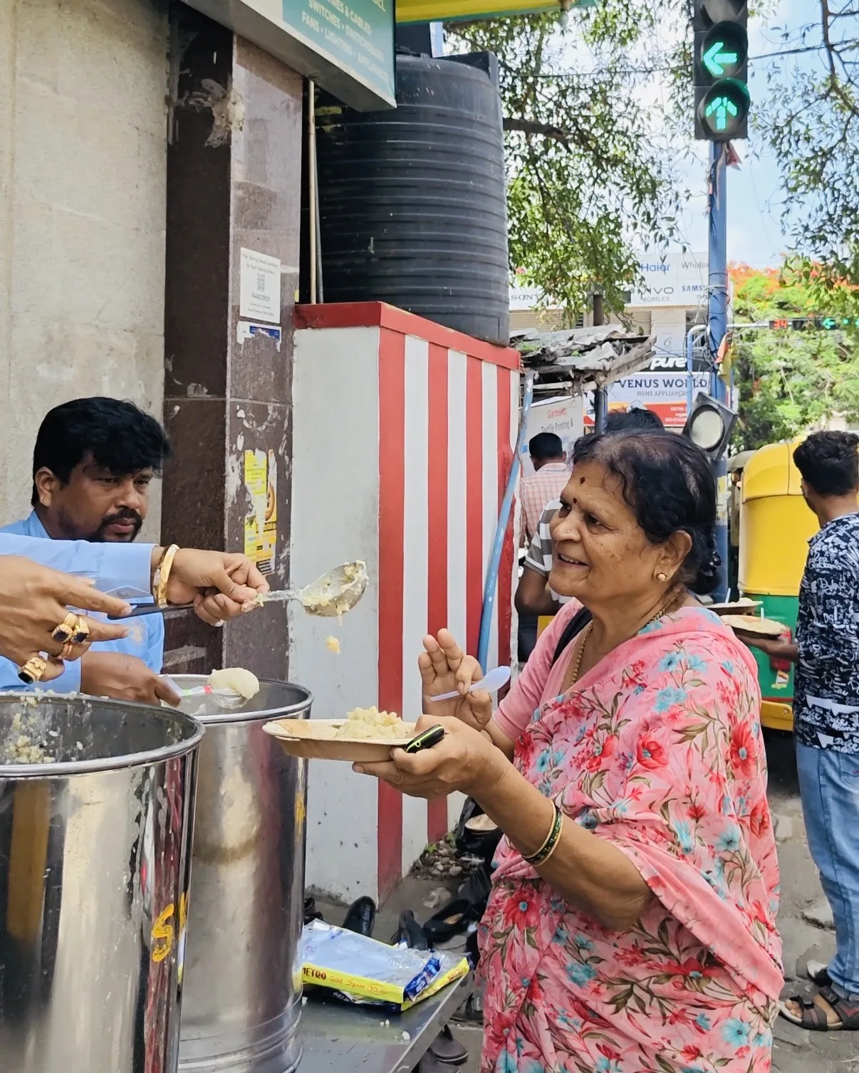 Dr. Chetan Kumar Mehta serving an Anna Danam meal to an elderly woman, Bengaluru