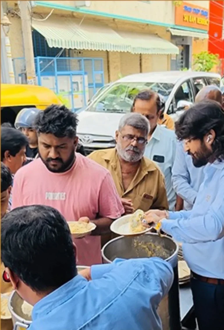Dr. Chetan Kumar Mehta and volunteers serving Anna Danam meals to a queue of men on a Bengaluru street